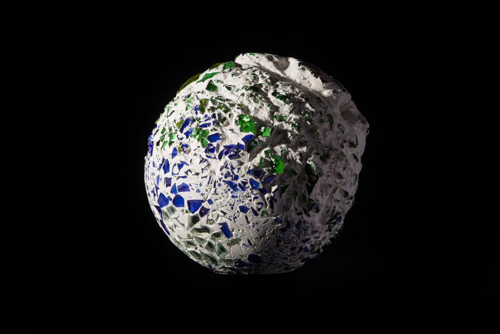 Roughly hewn Glass Globe on black background.