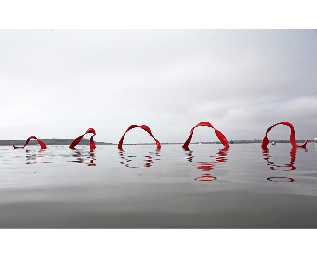 An archived, red, floating sculpure by Rebecca Newnham called Wave. Photographed by David Bird.